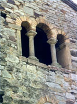 parte de un muro de piedra de una iglesia con ventana románica